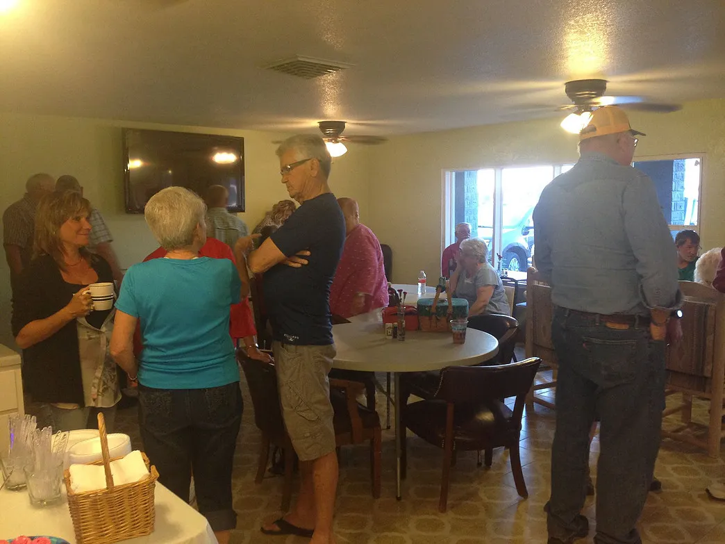 Guests socializing around tables in the Amigo Inn recreation hall