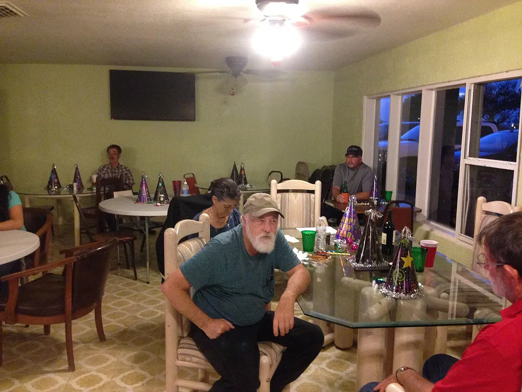 Guests seated at tables with New Year party hats during a holiday gathering at Amigo Inn