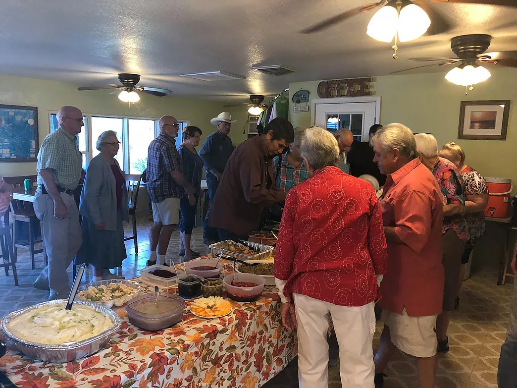 Guests gathered around an autumn-themed buffet table for a community meal at Amigo Inn